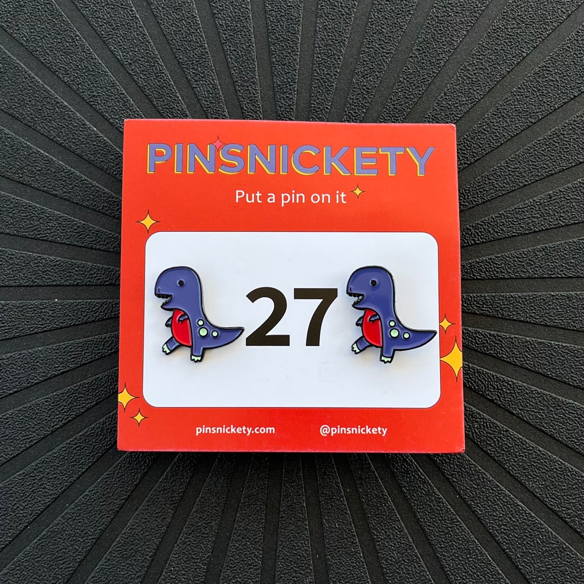 pinsnickety t-rex horse show number pins with their product packaging car on a black background