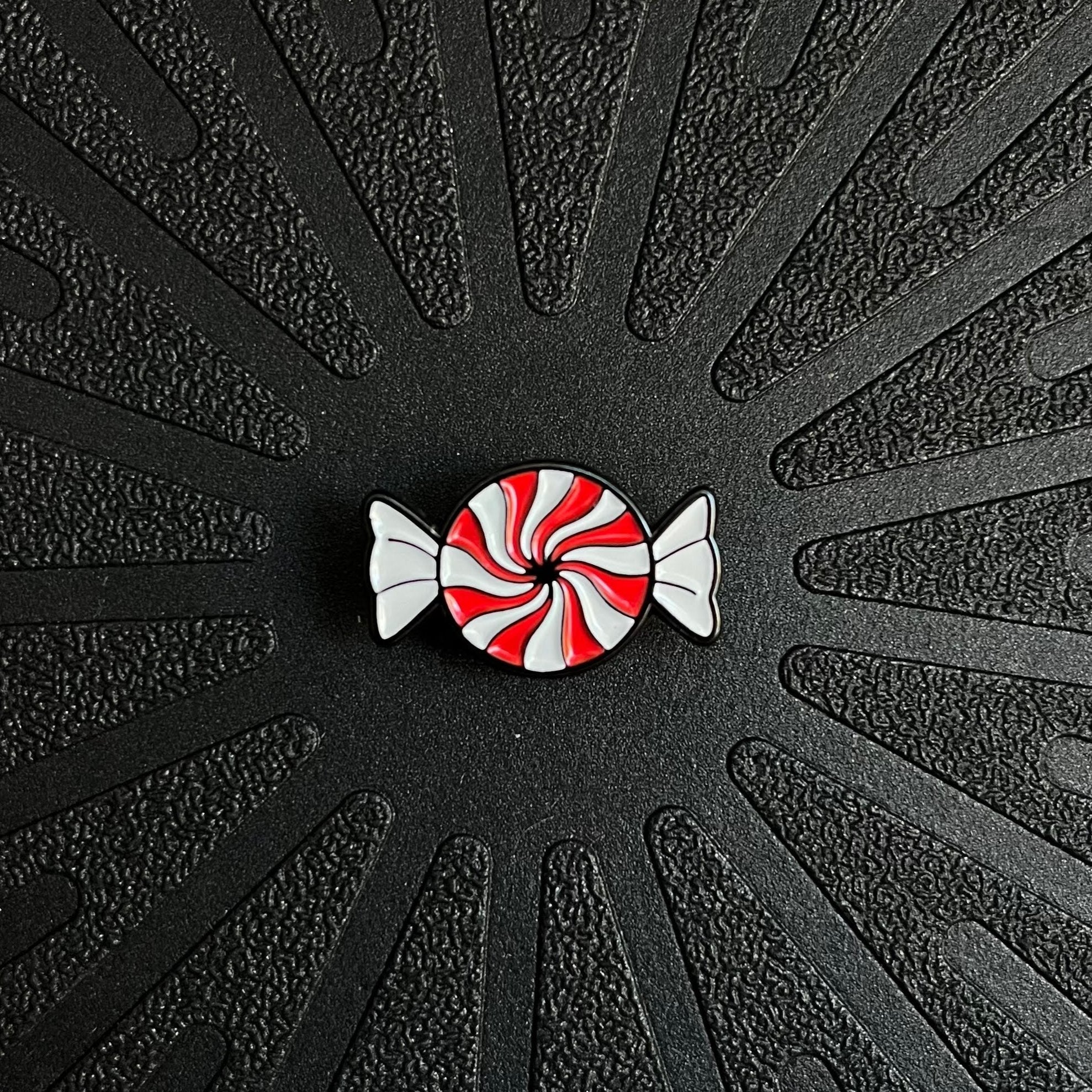 a single pinsnickety peppermint horse show number pin on a black background