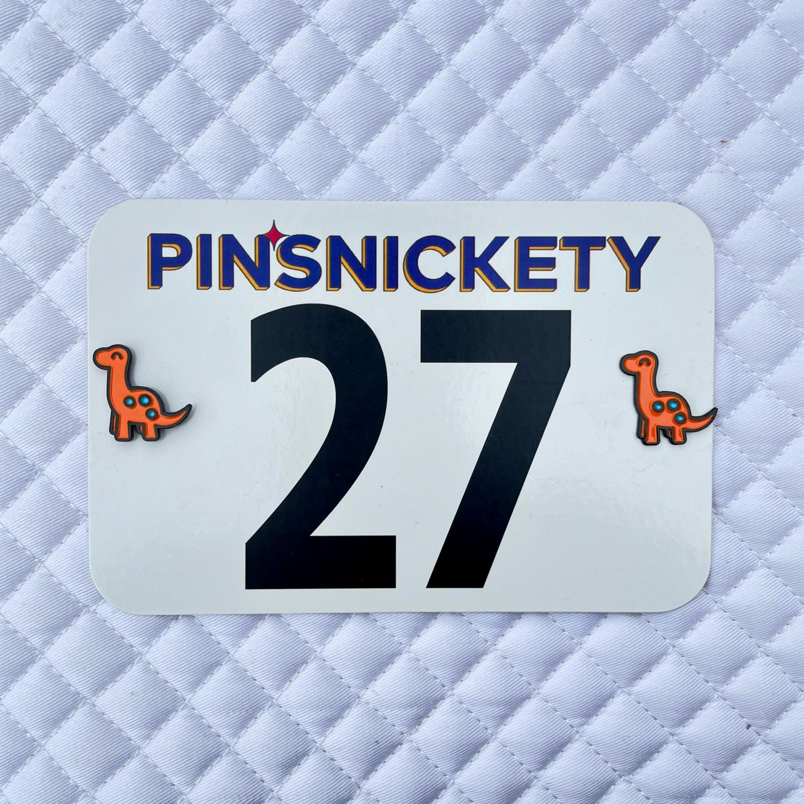 pinsnickety orange brontosaurus horse show number pins on a saddle pad