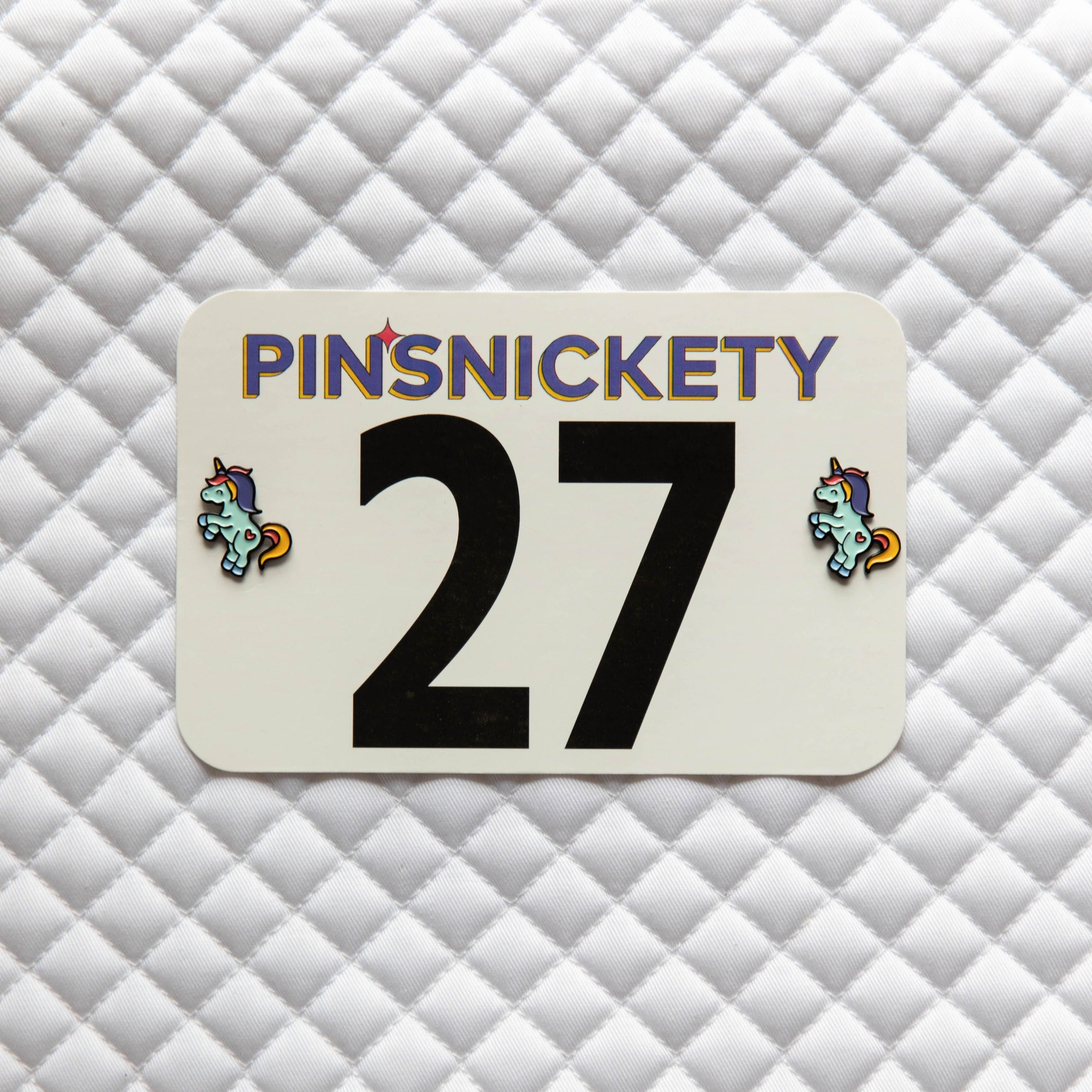 Pinsnickety Flying Unicorn horse show number pins on a saddle pad